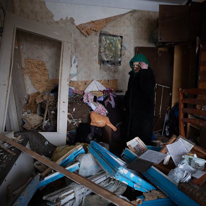 A woman standing amid rubble.