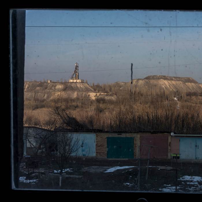 Small sheds in front of a brown field.